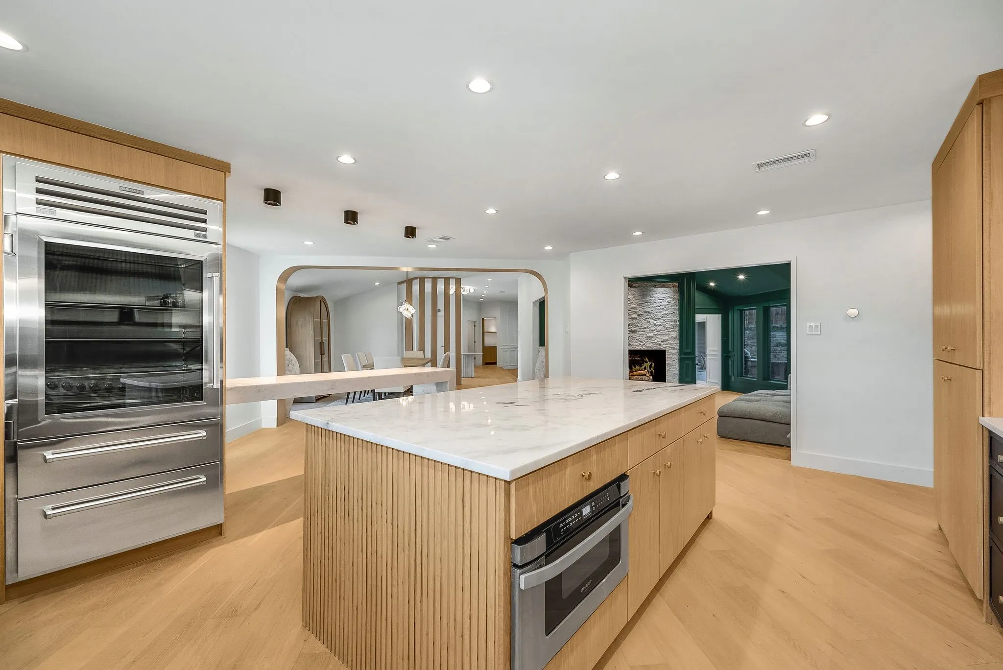 Kitchen featuring stainless steel appliances, light brown cabinetry, recessed lighting, a large island, and open floor plan