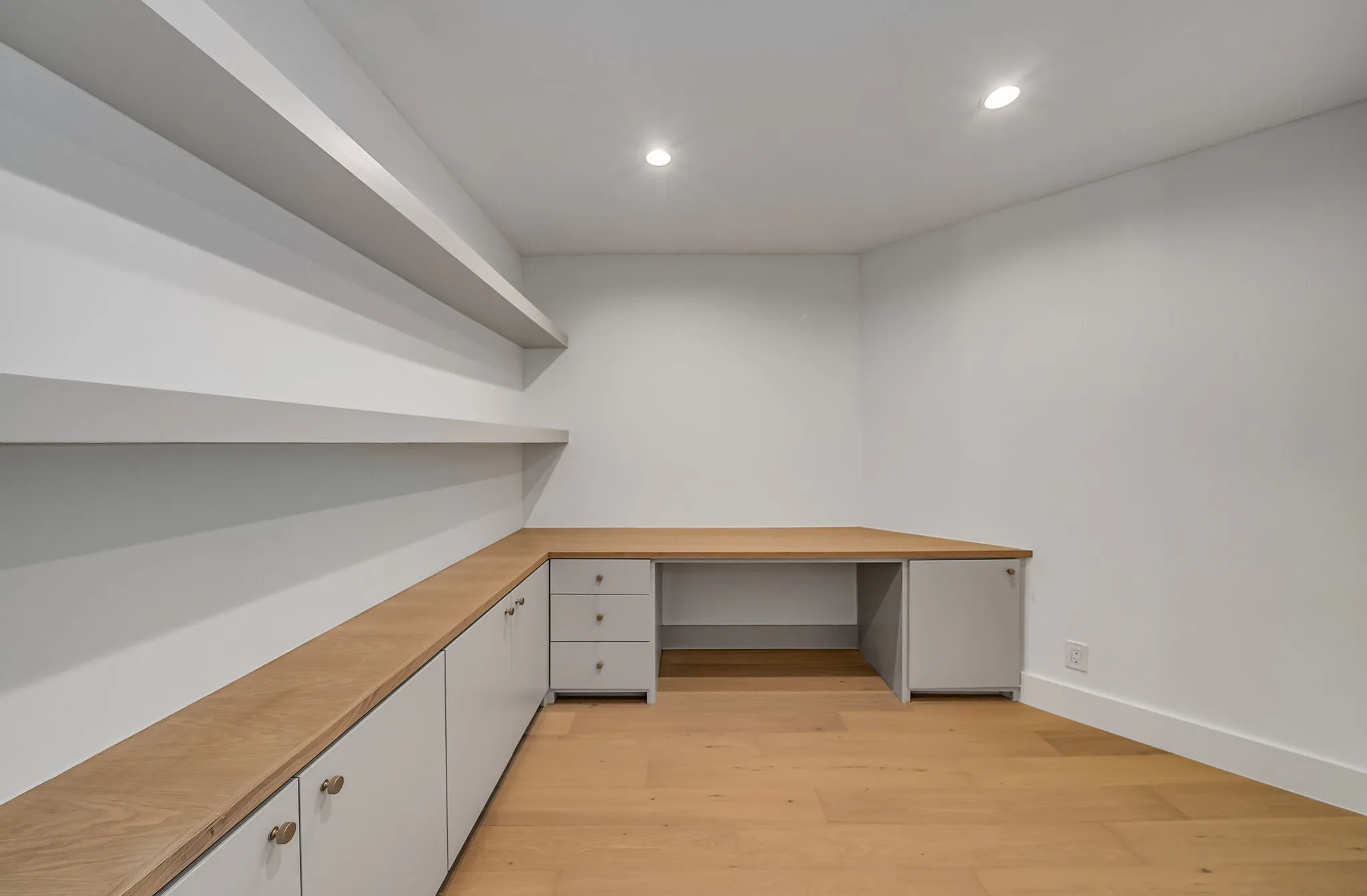 Unfurnished office with built in desk, recessed lighting, and light wood-type flooring