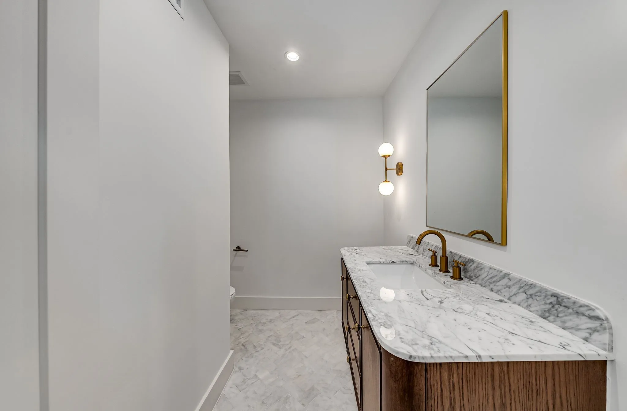 Half bathroom with vanity and recessed lighting