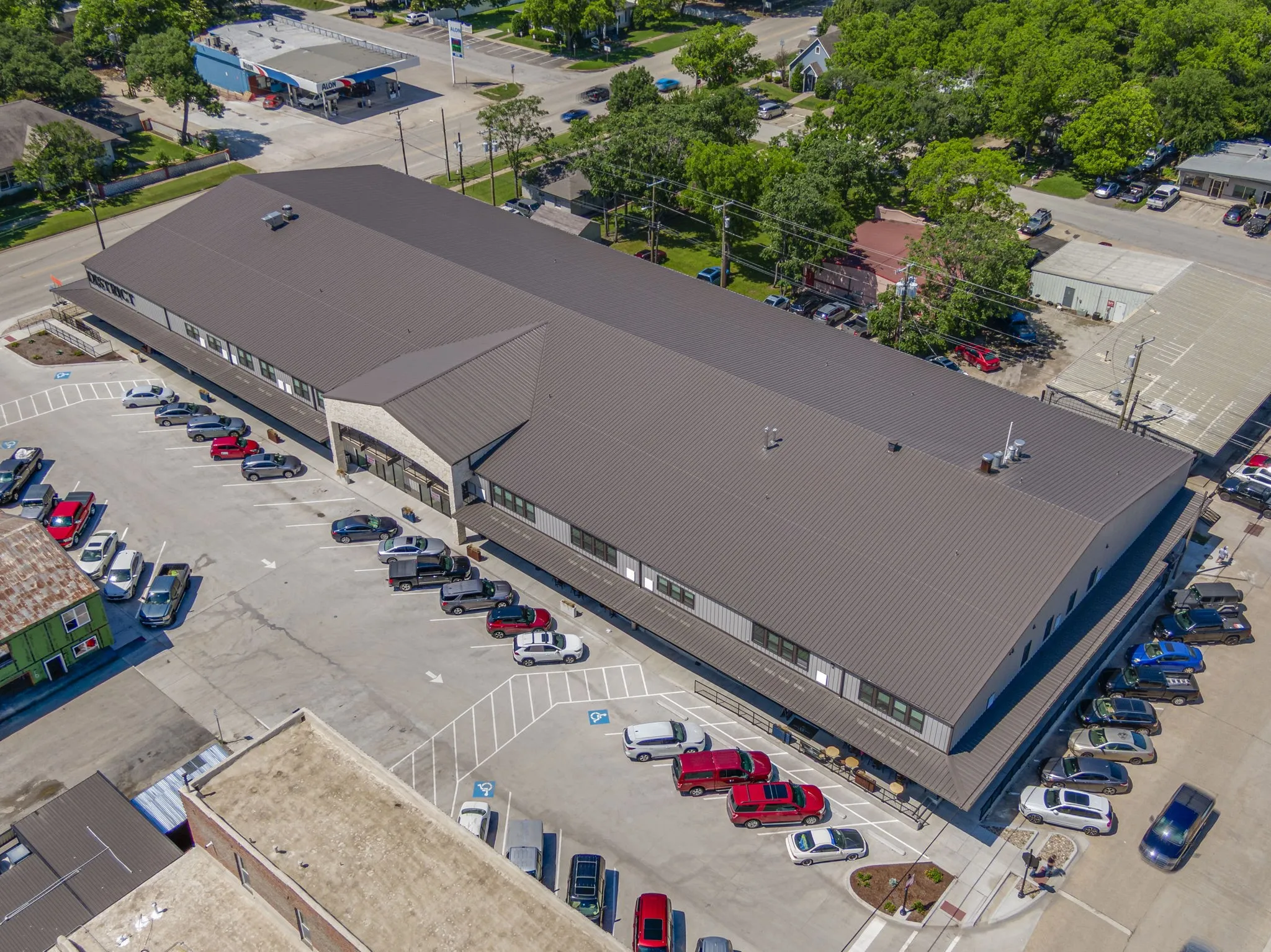 Large commercial building with a dark metal roof and light gray siding