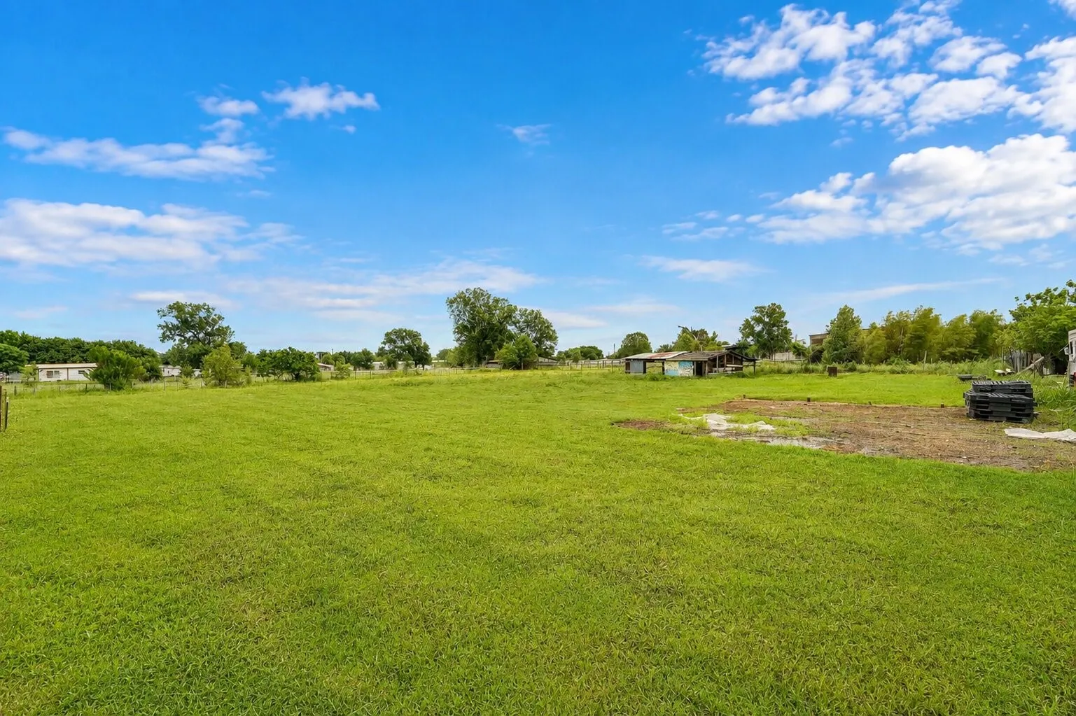 Expansive green space with mature trees and open-air structures