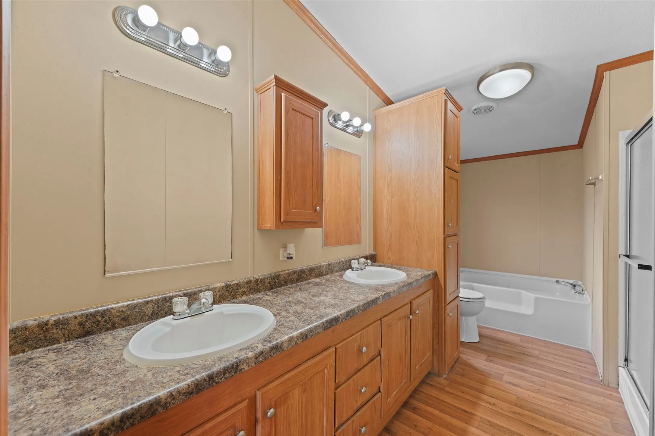 Dual vanity with wood cabinetry and laminate countertops