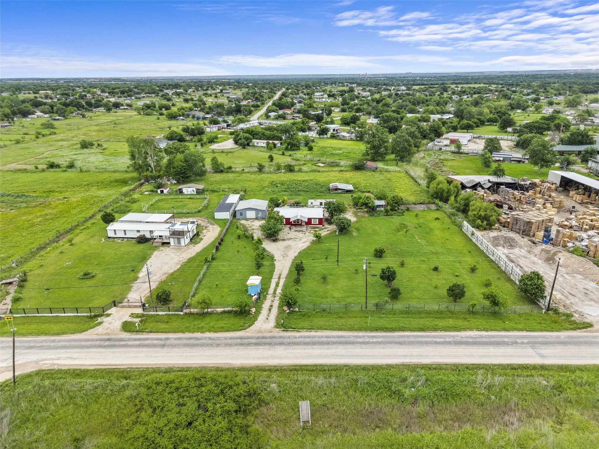 Expansive property featuring two structures, a detached garage, and a long gravel driveway