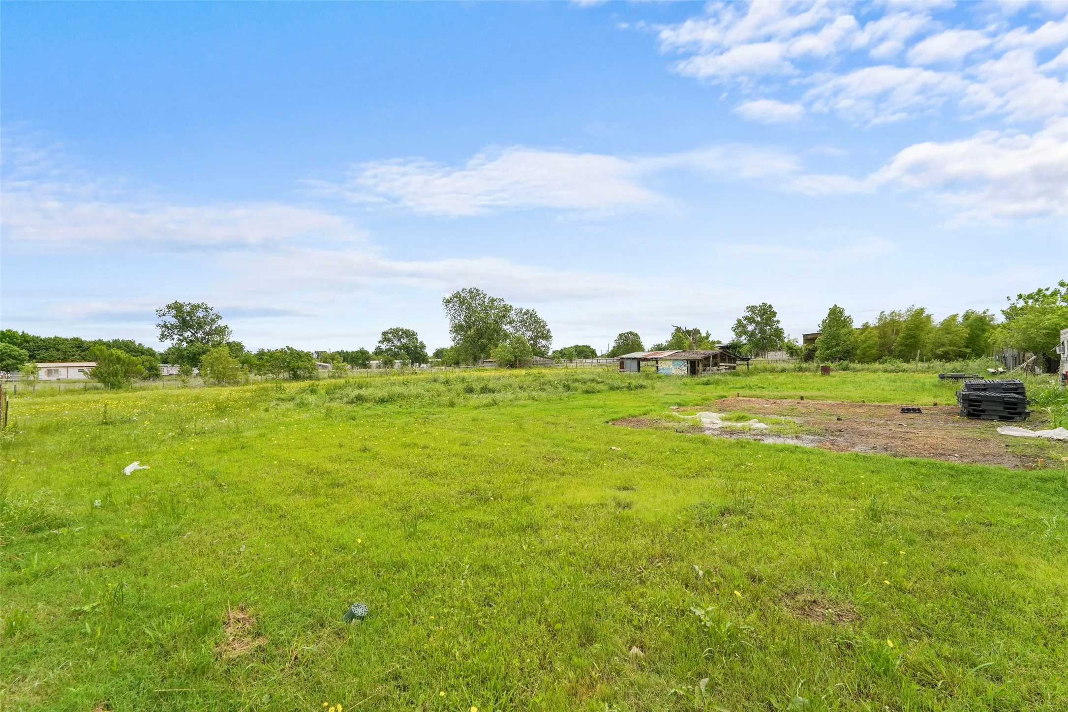 Expansive green grass lot with a clear sky backdrop