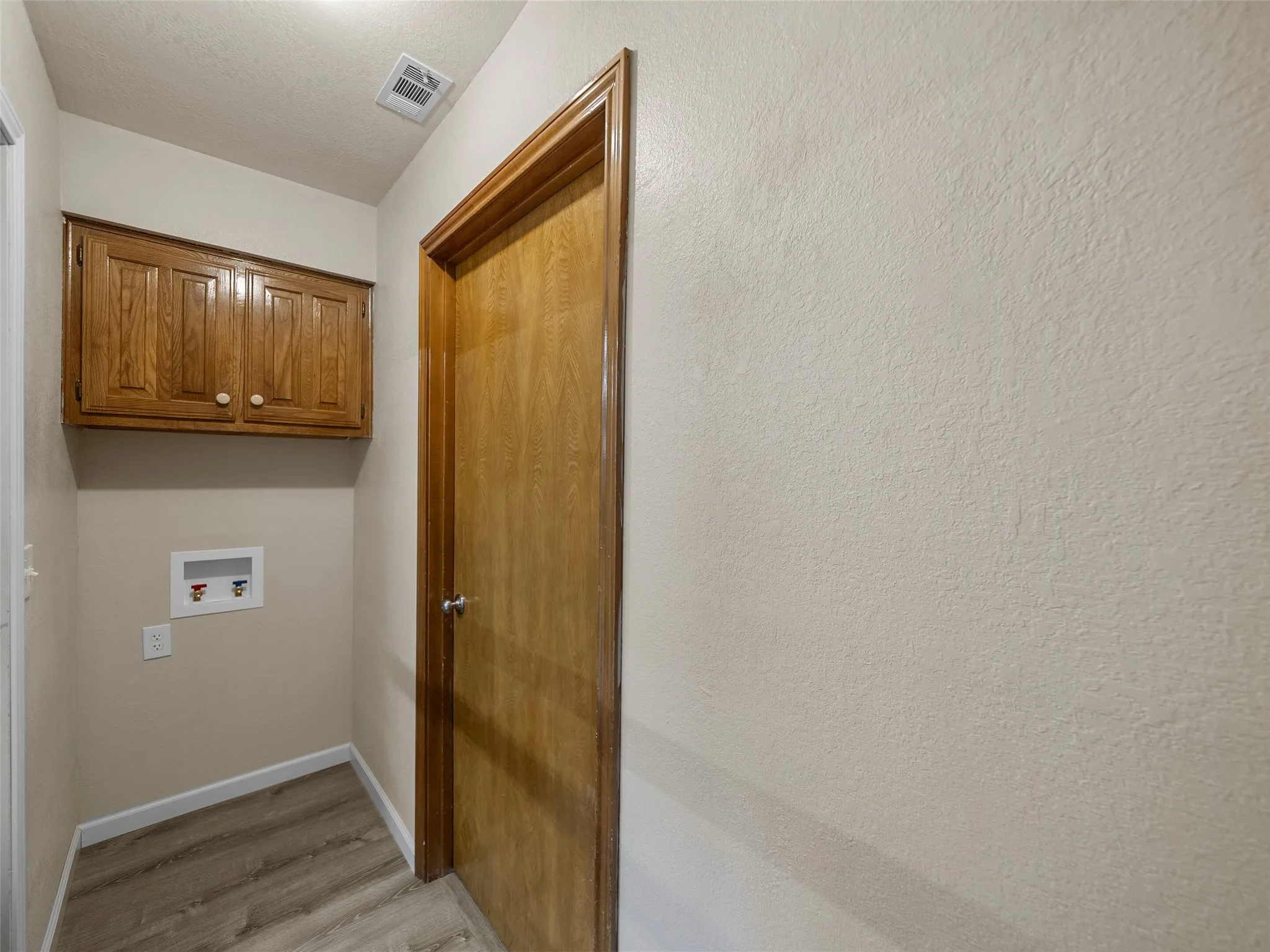 The full-size laundry area has built-in cabinetry and the washer is on one side and the dry is one the opposite side.  The entry to the garage is in the middle.