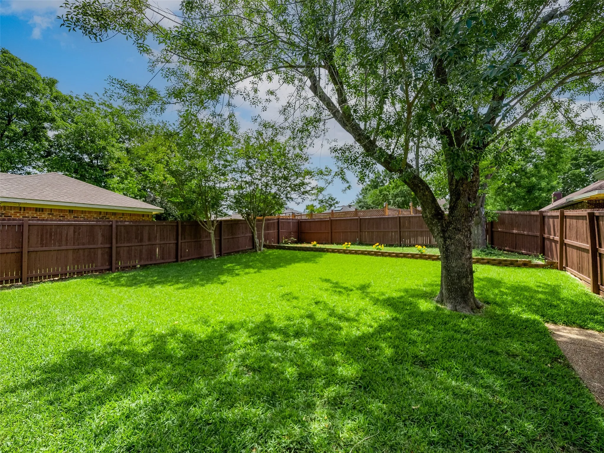 The large, fully fenced backyard provides plenty of grassy space for pets, play, or outdoor entertaining.