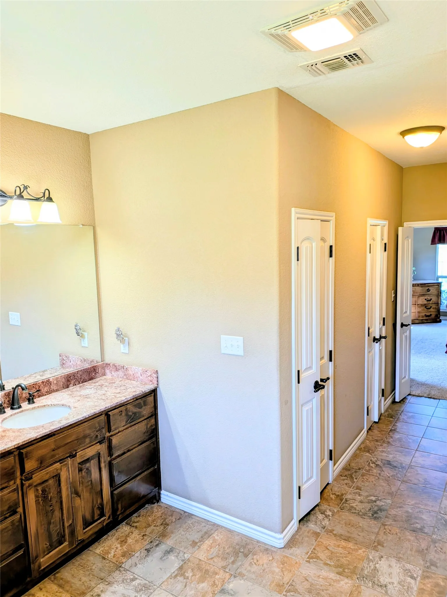 2nd lavatory also showing water closet door and walkway into bathroom from master