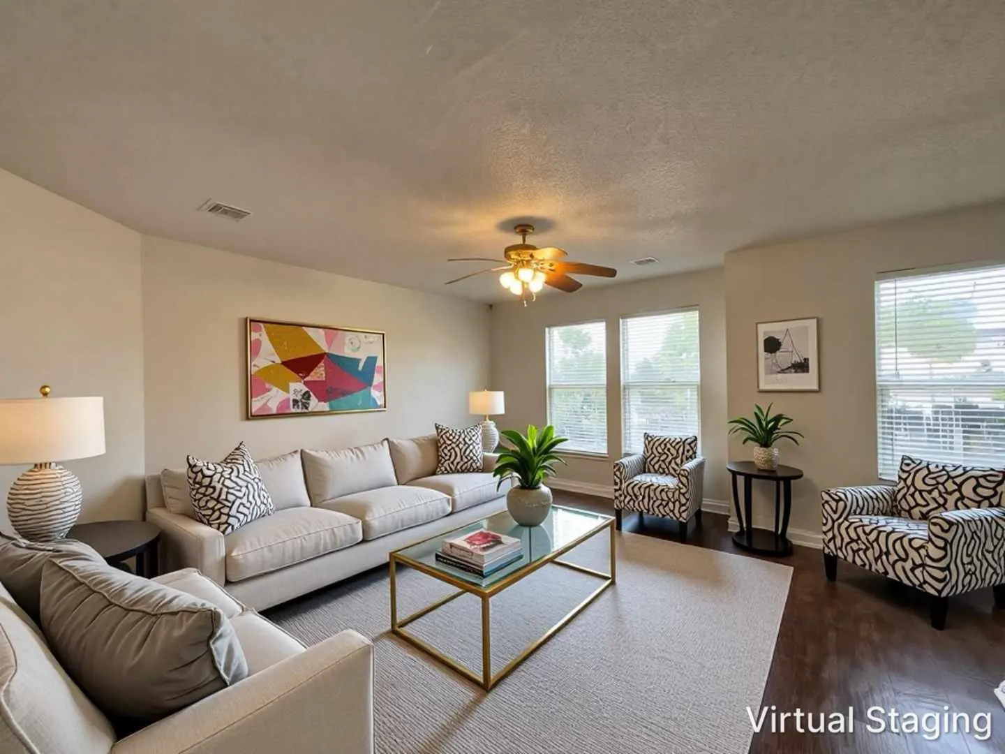 Spacious living area featuring dark wood-finish flooring, multiple windows providing ample natural light, a ceiling fan fixture, and neutral wall tones