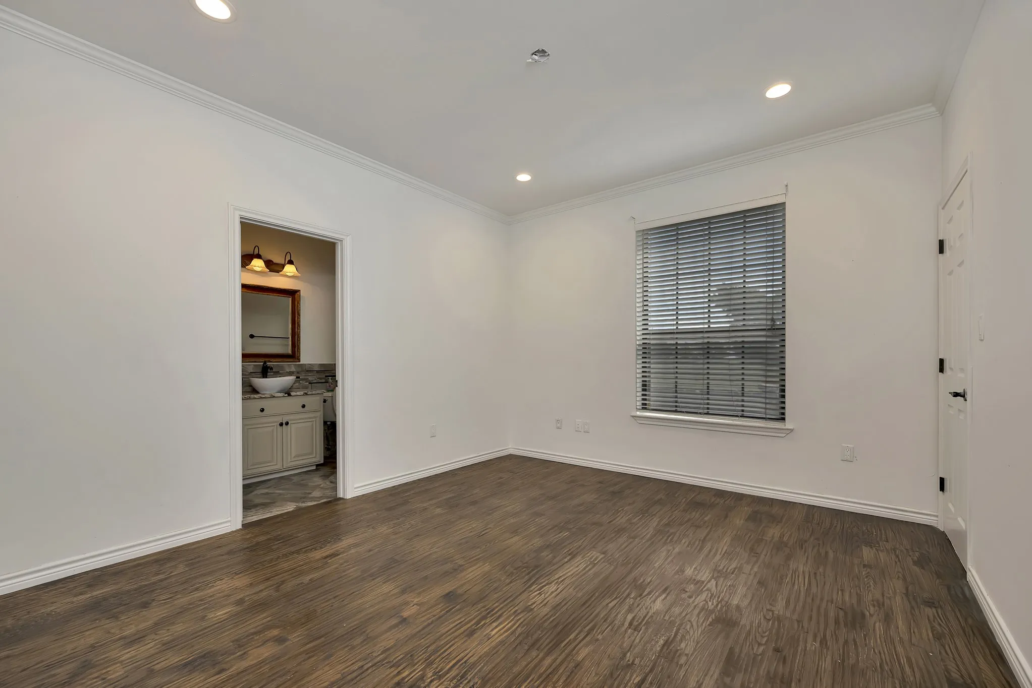 Empty room with crown molding, dark wood-style flooring, and recessed lighting
