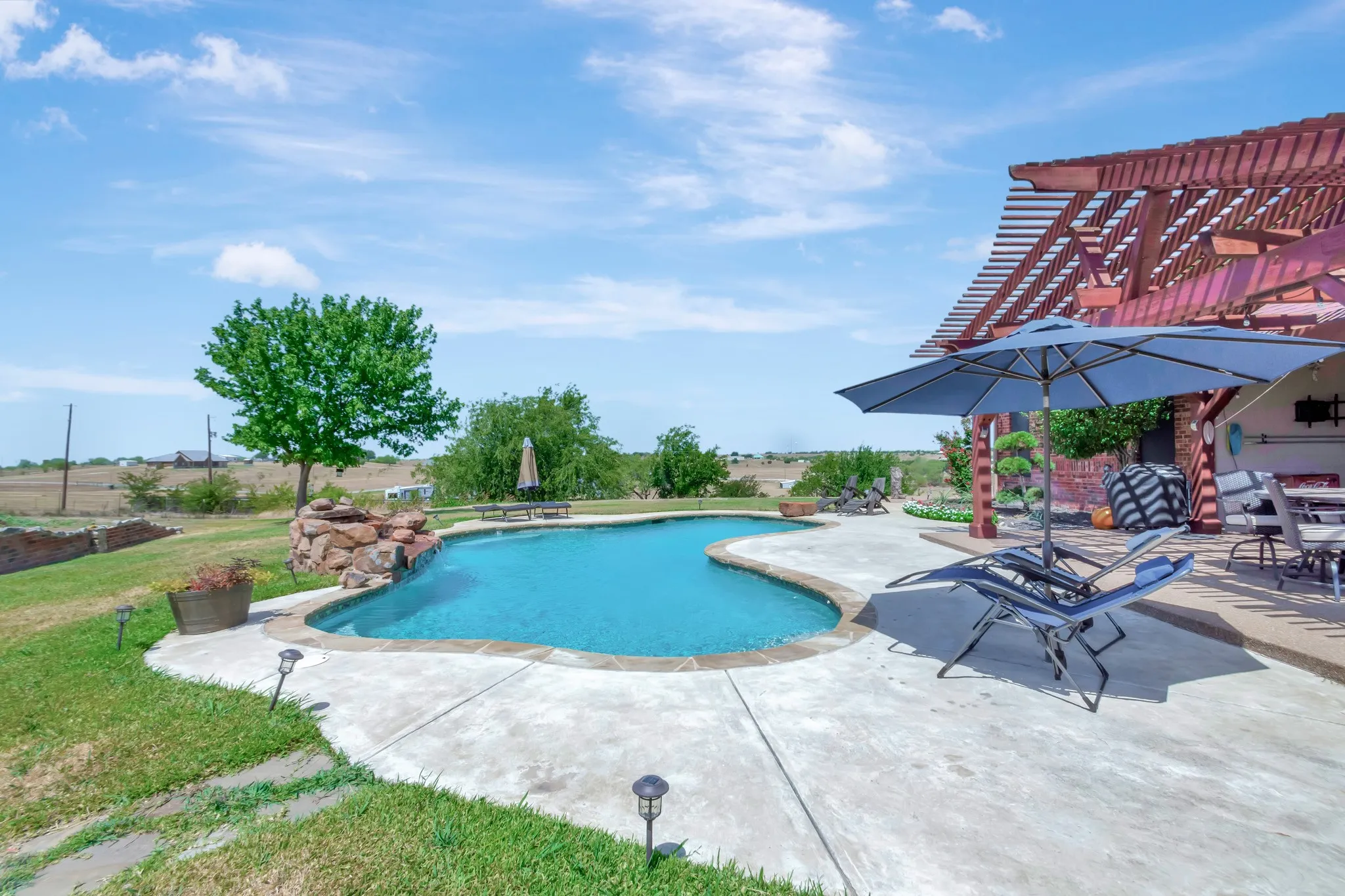 Outdoor pool featuring a pergola, a patio, and a lawn