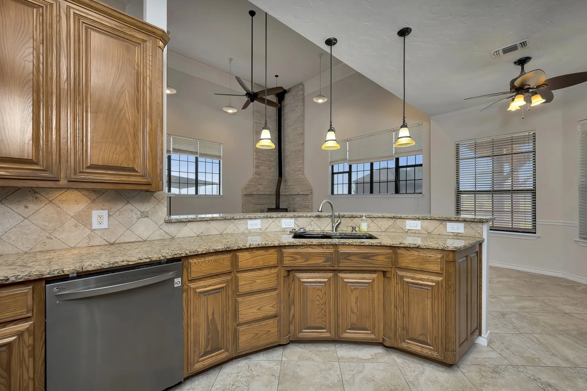 Kitchen with dishwasher, a ceiling fan, and brown cabinets