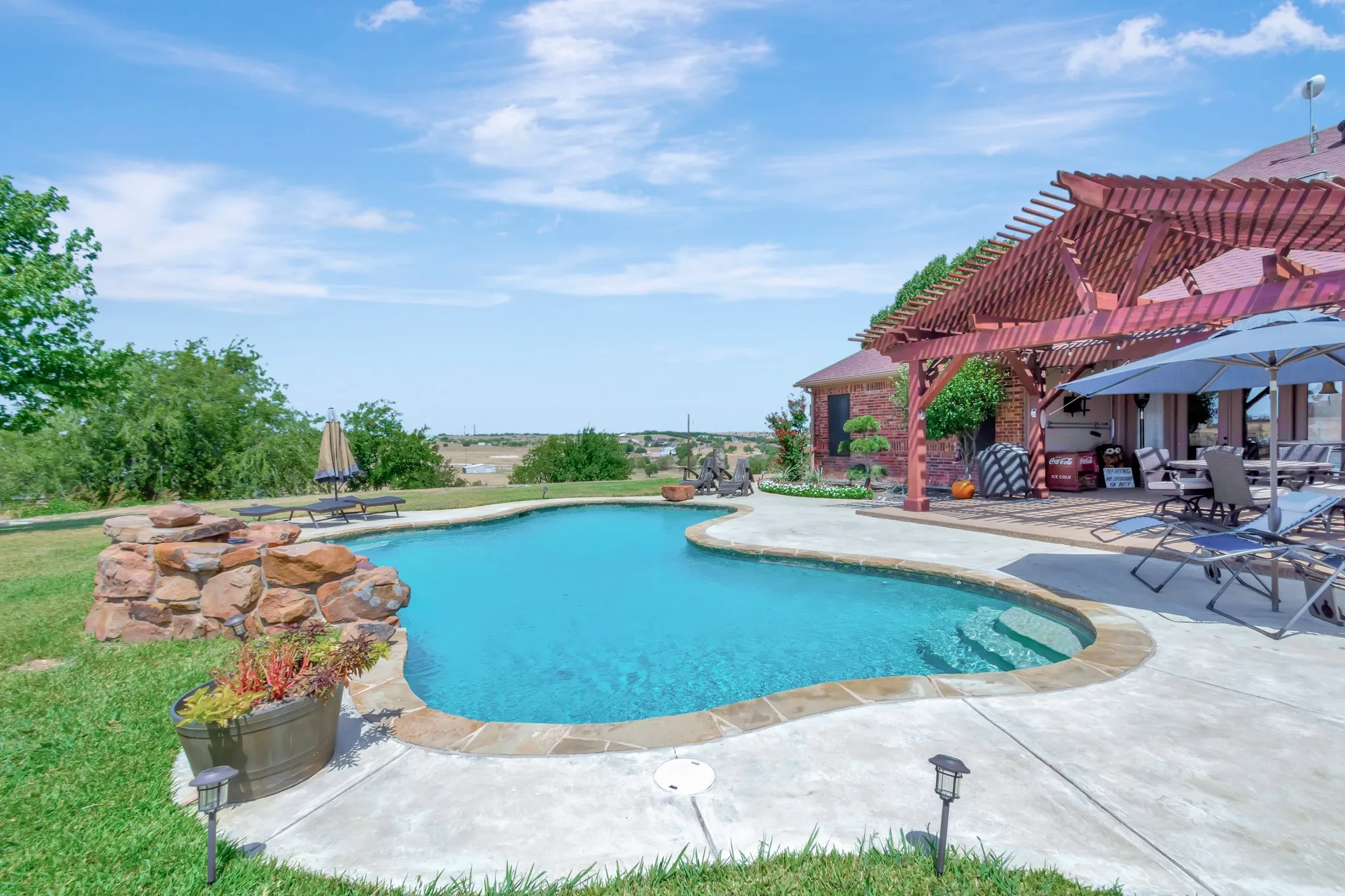 Swimming pool featuring a pergola and a patio area