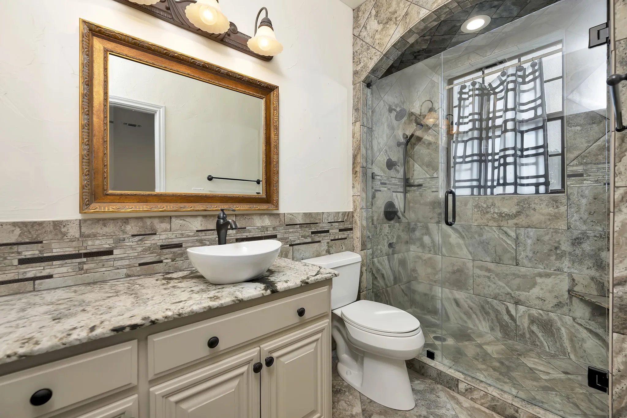 Full bathroom with tile walls, vanity, a shower stall, and a wainscoted wall