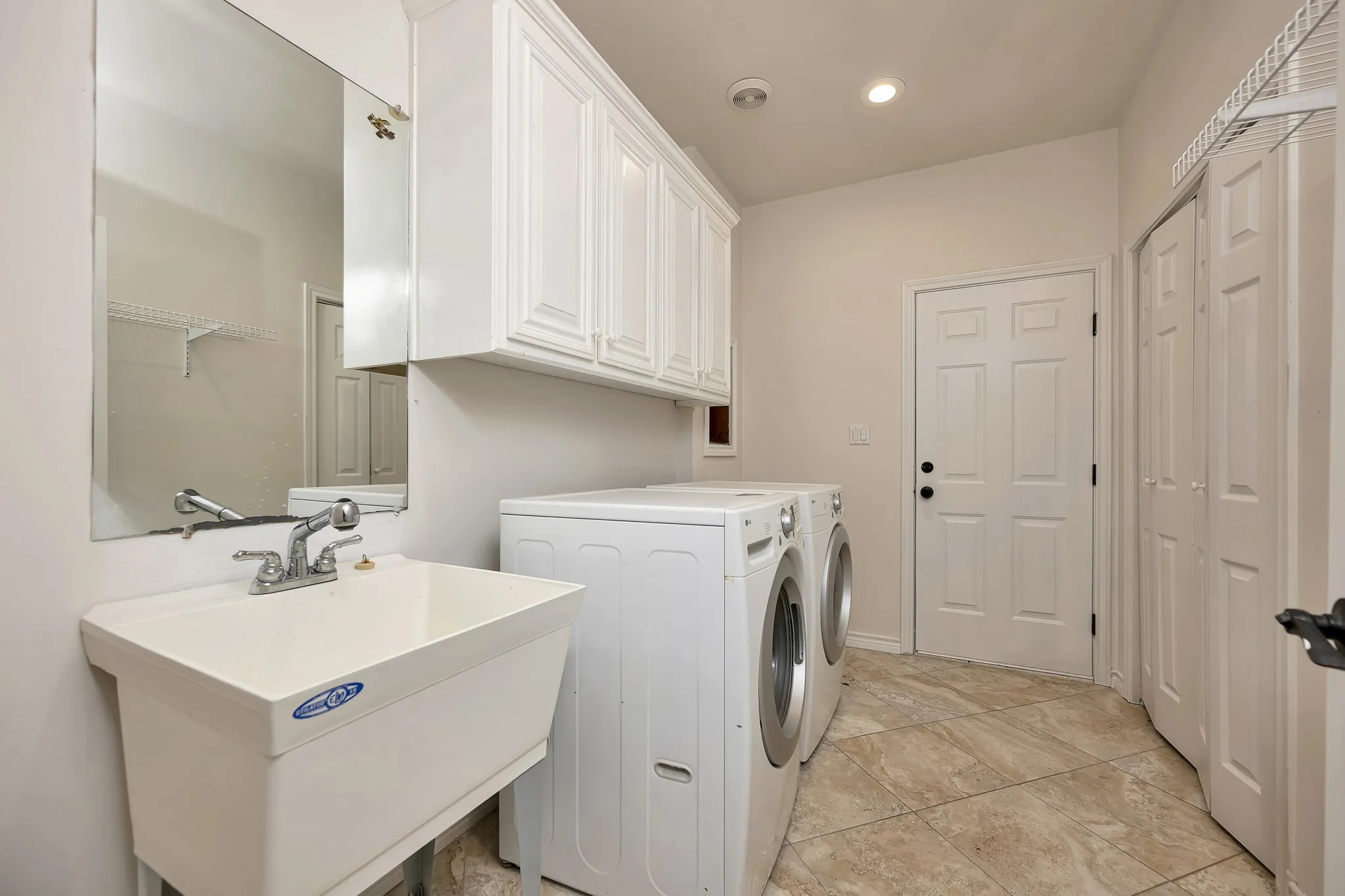 Laundry room featuring washer and clothes dryer, cabinet space, and recessed lighting