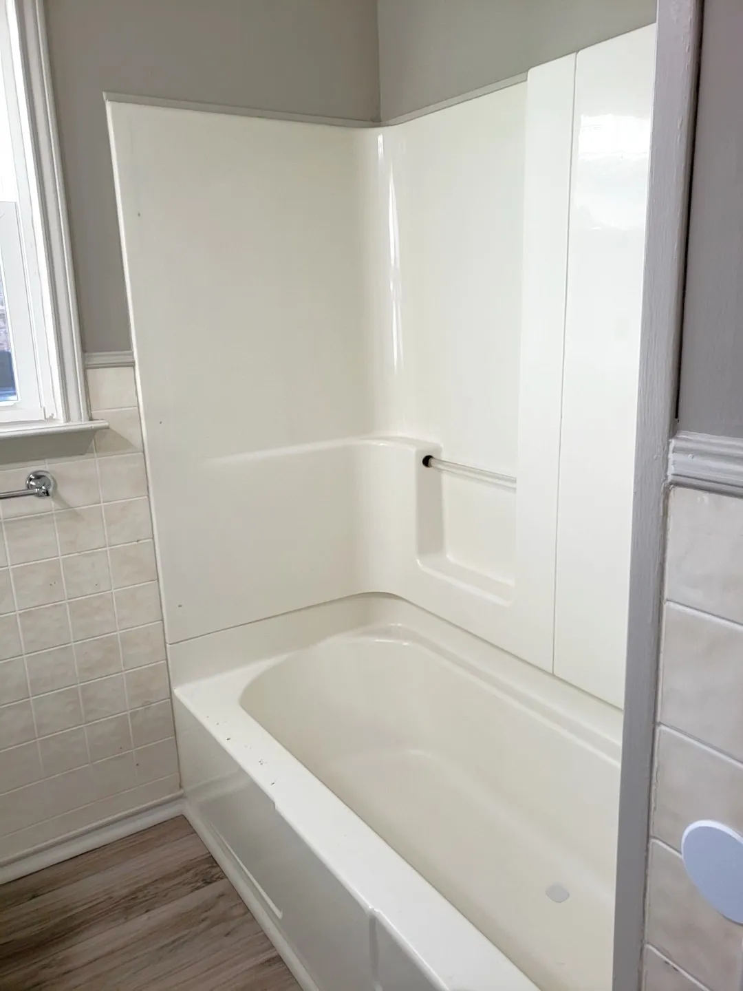 Bathtub with integrated surround, tiled wall accents
