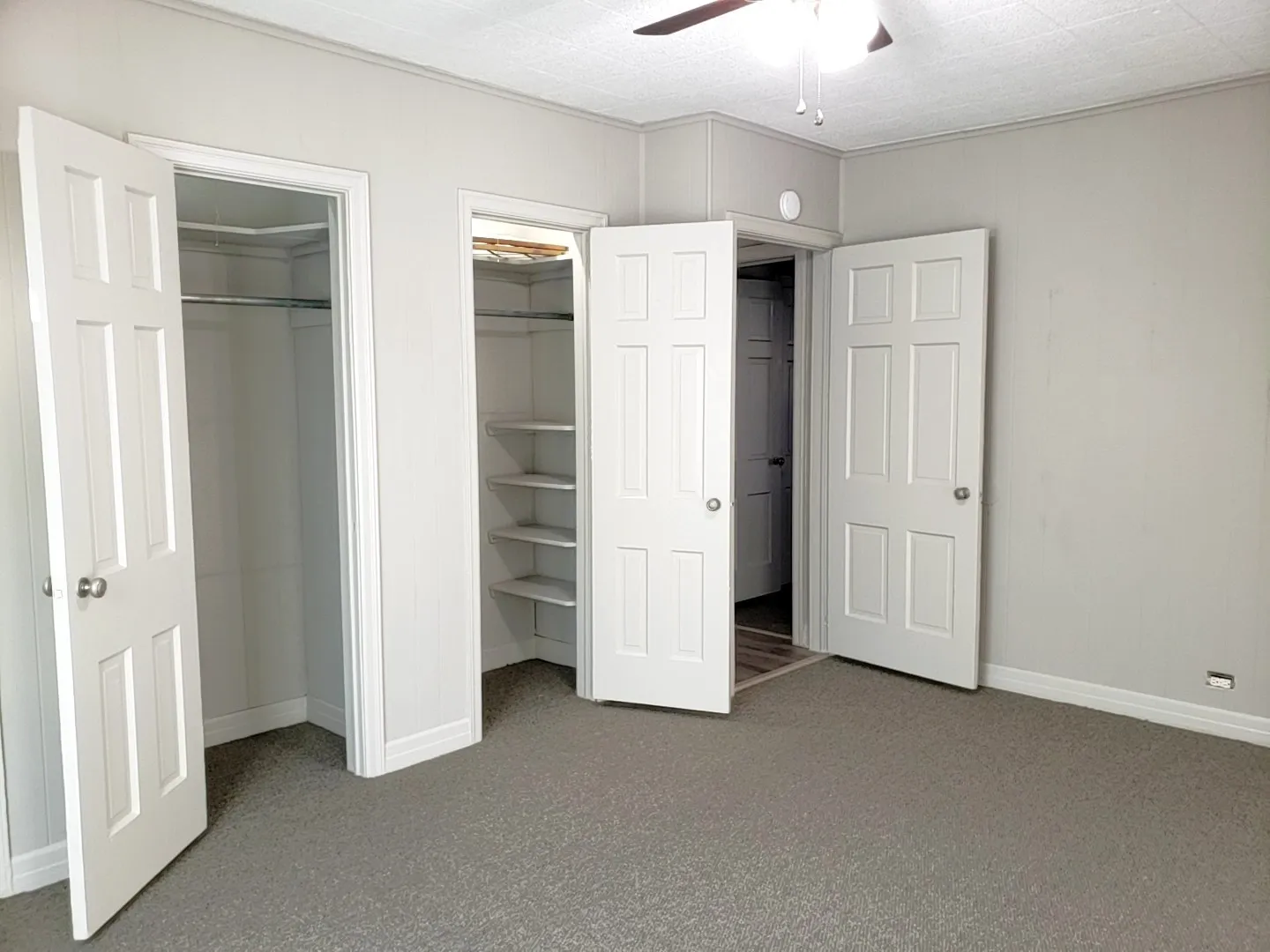 Bedroom featuring textured carpeting, light gray wall paint, and white trim