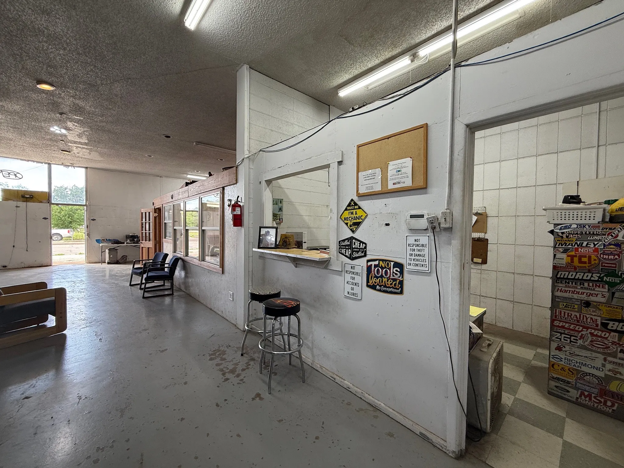 Spacious reception area featuring a service counter with pass-through window and industrial concrete flooring
