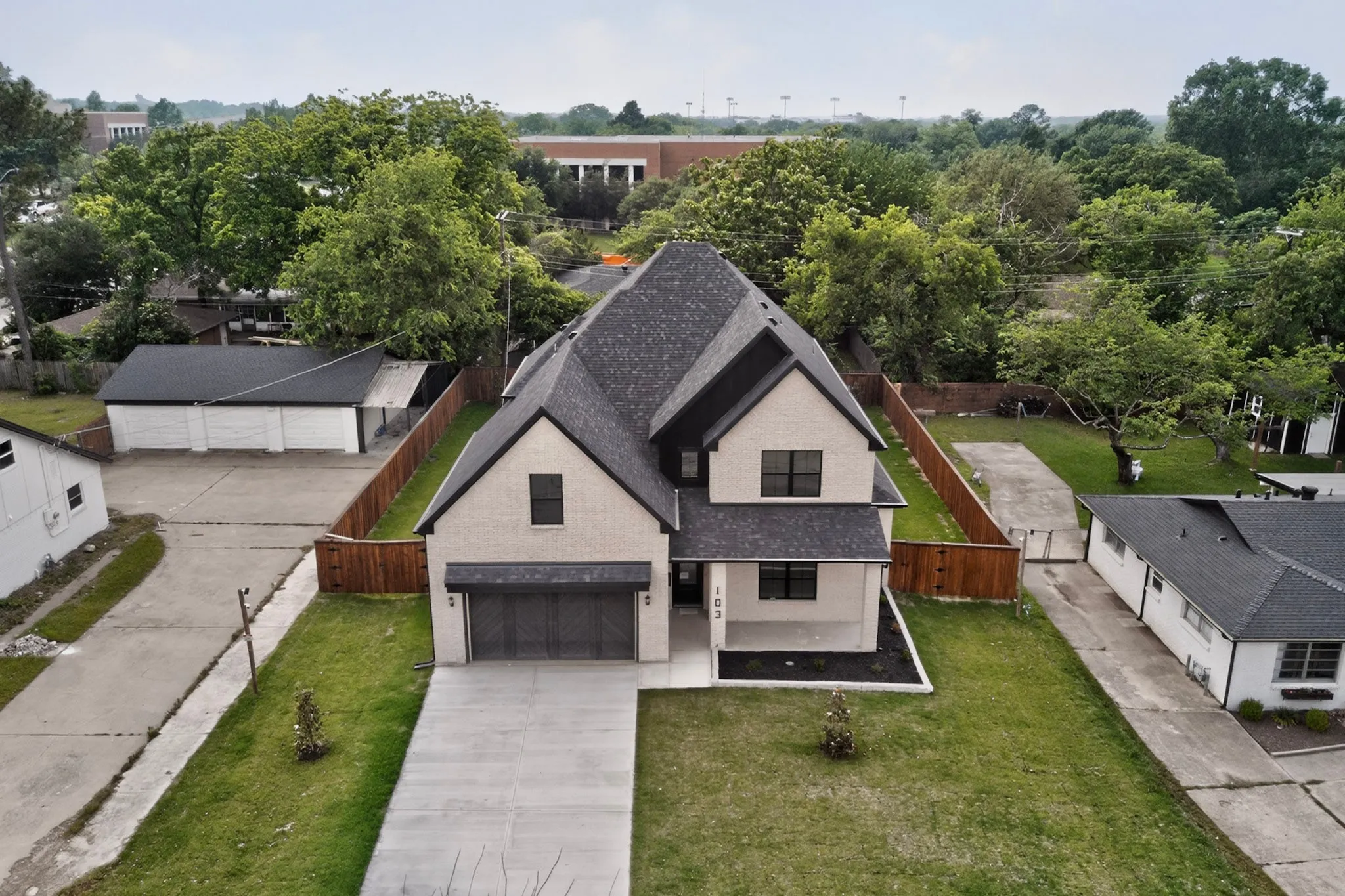 Modern two-story residence featuring light-colored brick and dark trim
