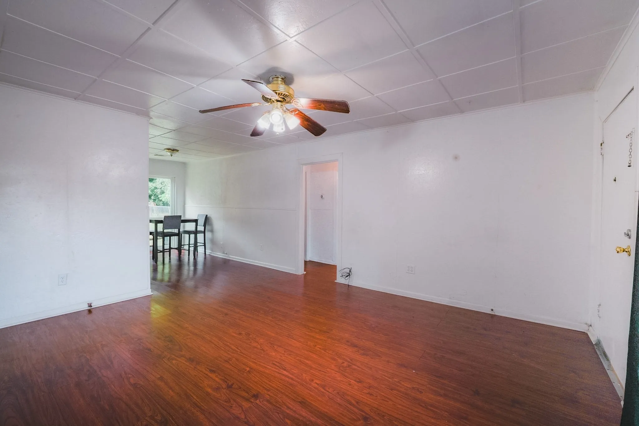 Wood-finish flooring throughout, complemented by white walls and a white panel ceiling