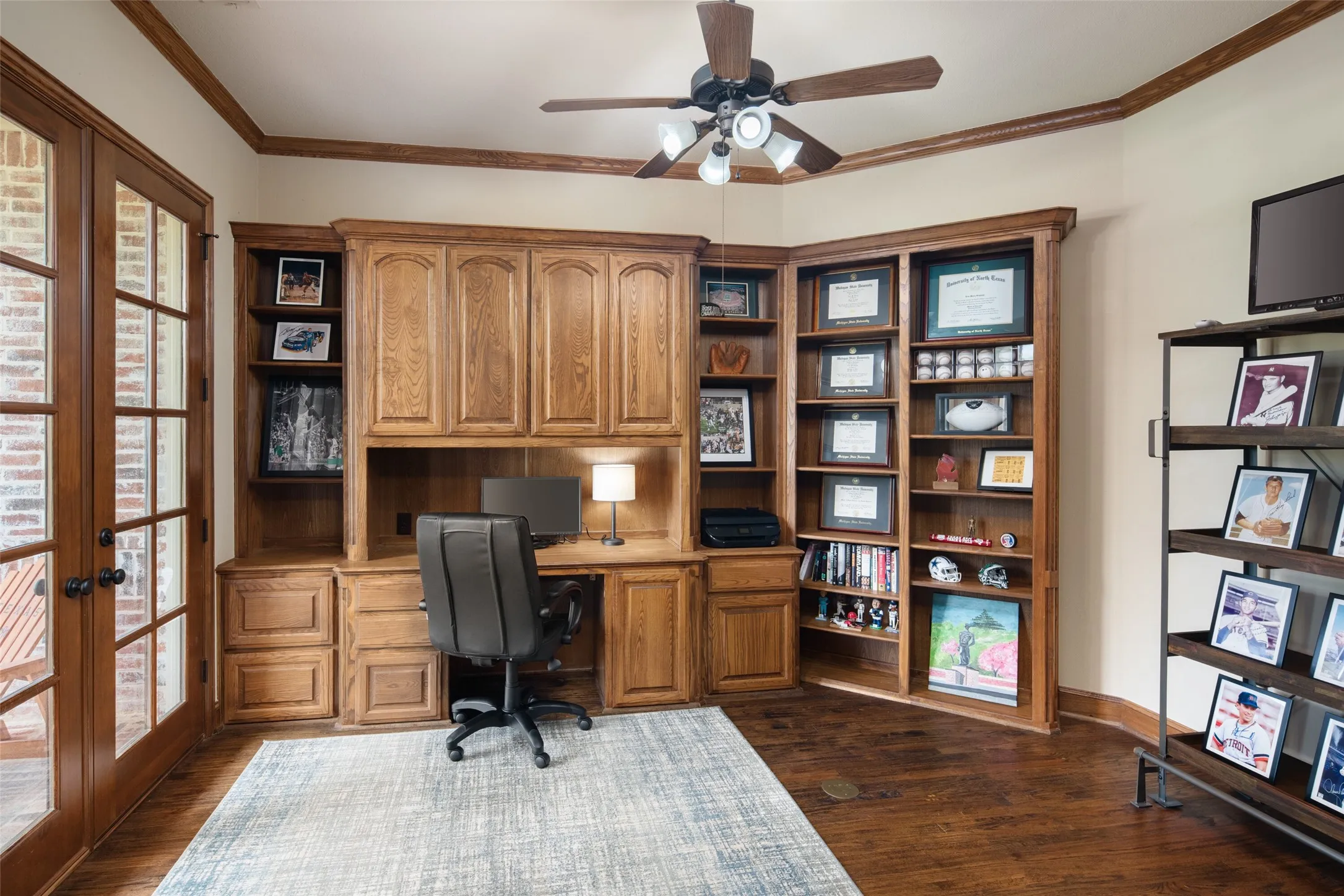 Handsome Study with Hardwood Floors, Custom Built in, and French Doors with patio. Perfect Remote Work Space
