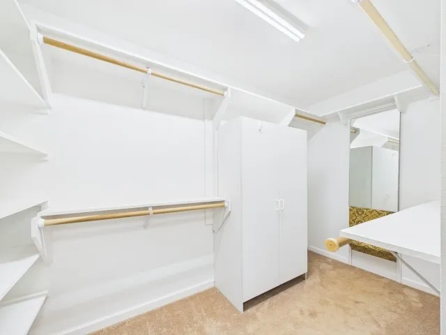 Guest quarters - walk in custom closet with hidden gun rack behind the mirror