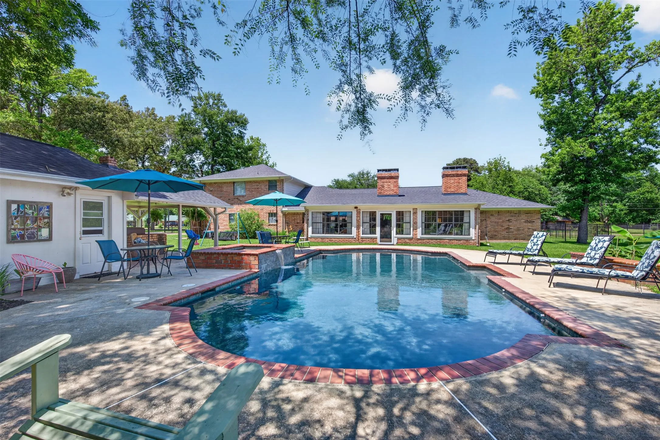 Rectangular swimming pool featuring a brick coping and concrete surround