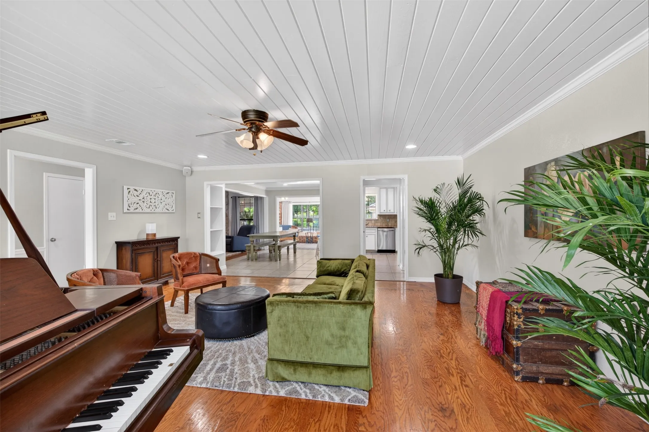 Hardwood flooring throughout the main living space with a white paneled ceiling