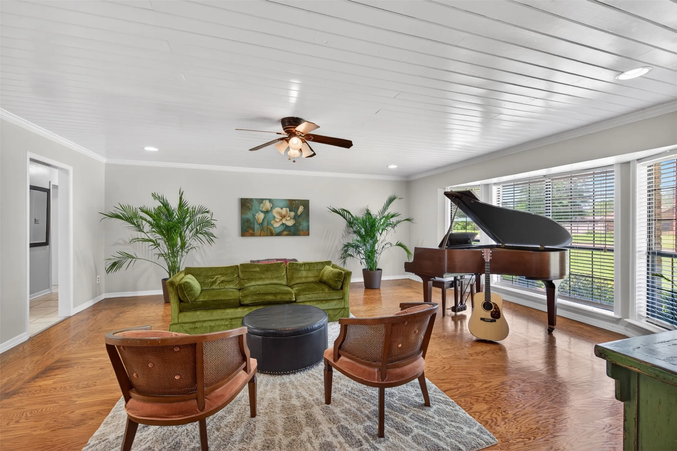 Bright room featuring wood-finish flooring, white paneled ceiling, recessed lighting, and a ceiling fan