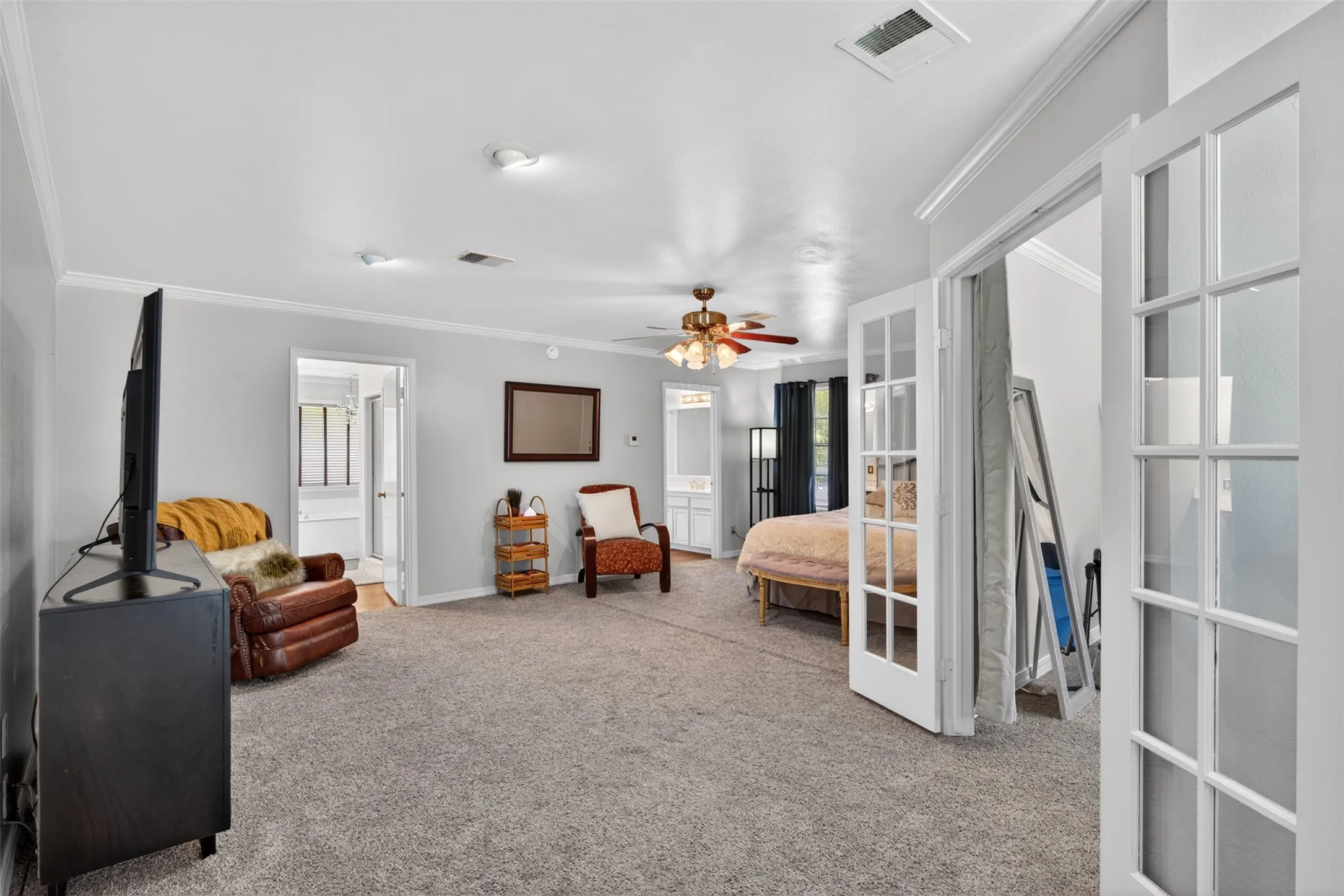 Spacious room featuring neutral carpeting and crown molding