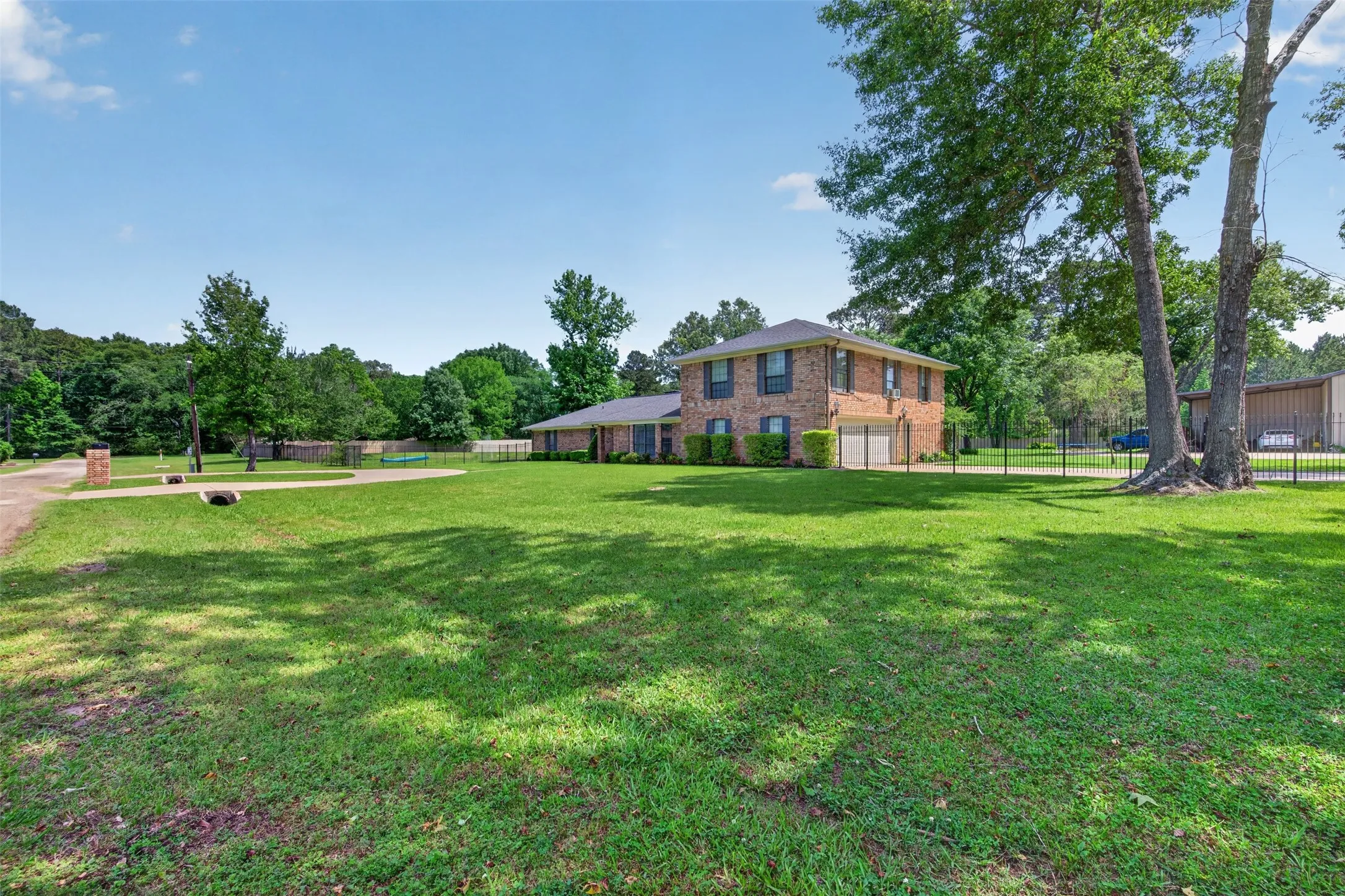 Brick residence with a two-story elevation, featuring an attached garage with a white gate
