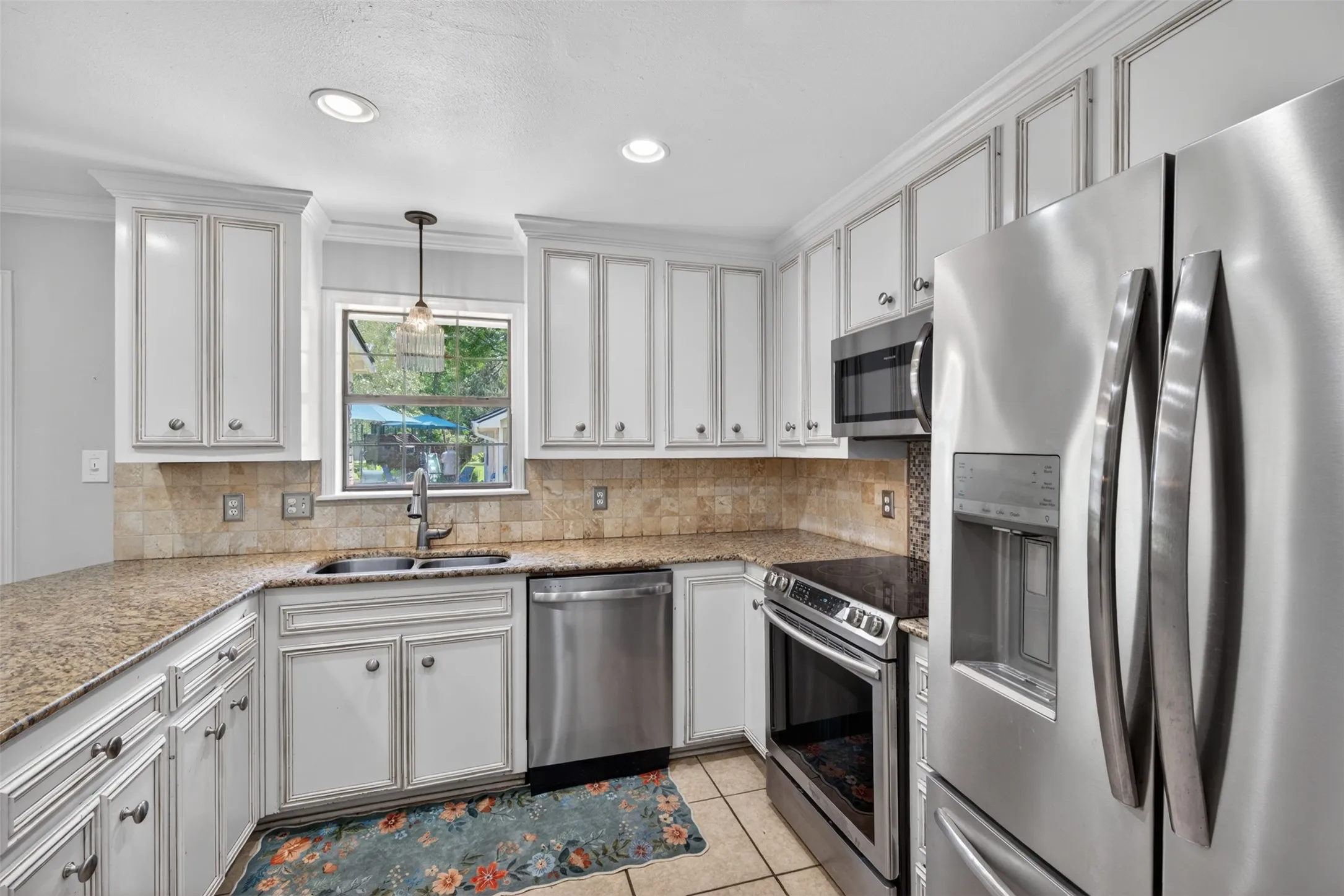 Kitchen featuring white cabinetry, granite countertops, stainless steel appliances, a tile backsplash, and recessed lighting