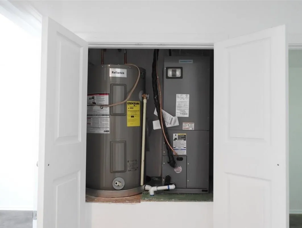 Utility closet housing a water heater and HVAC air handler