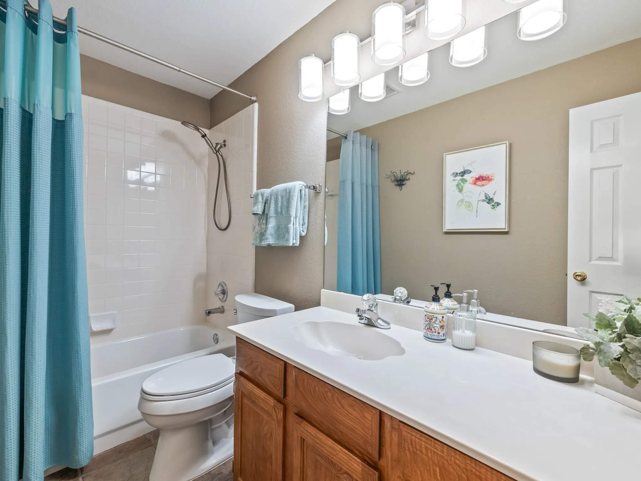 Bathroom featuring a vanity with wood-finish cabinetry, a white countertop, and an integrated sink basin
