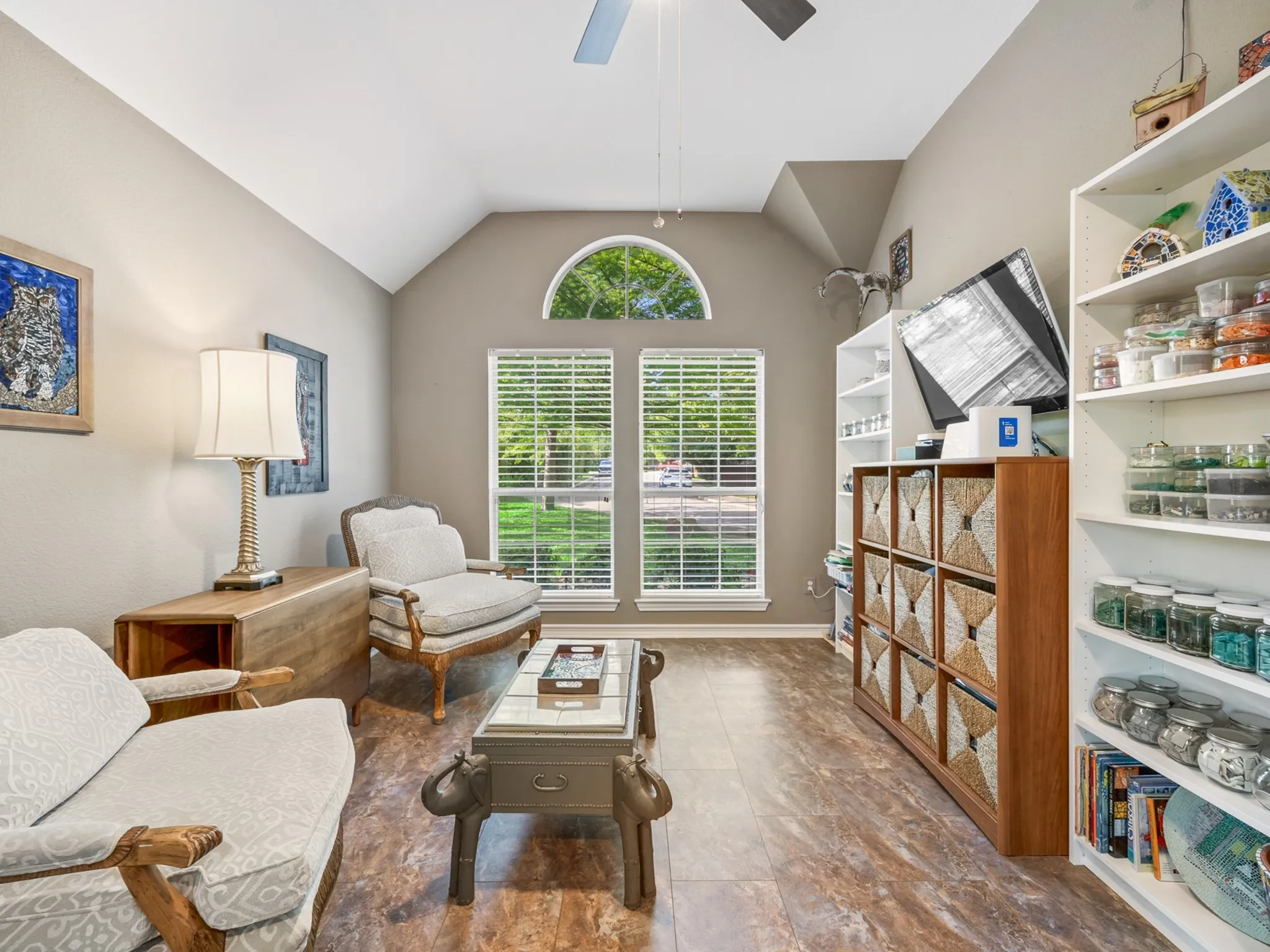 Living area with vaulted ceilings, a large arched transom window, and wood-finish flooring