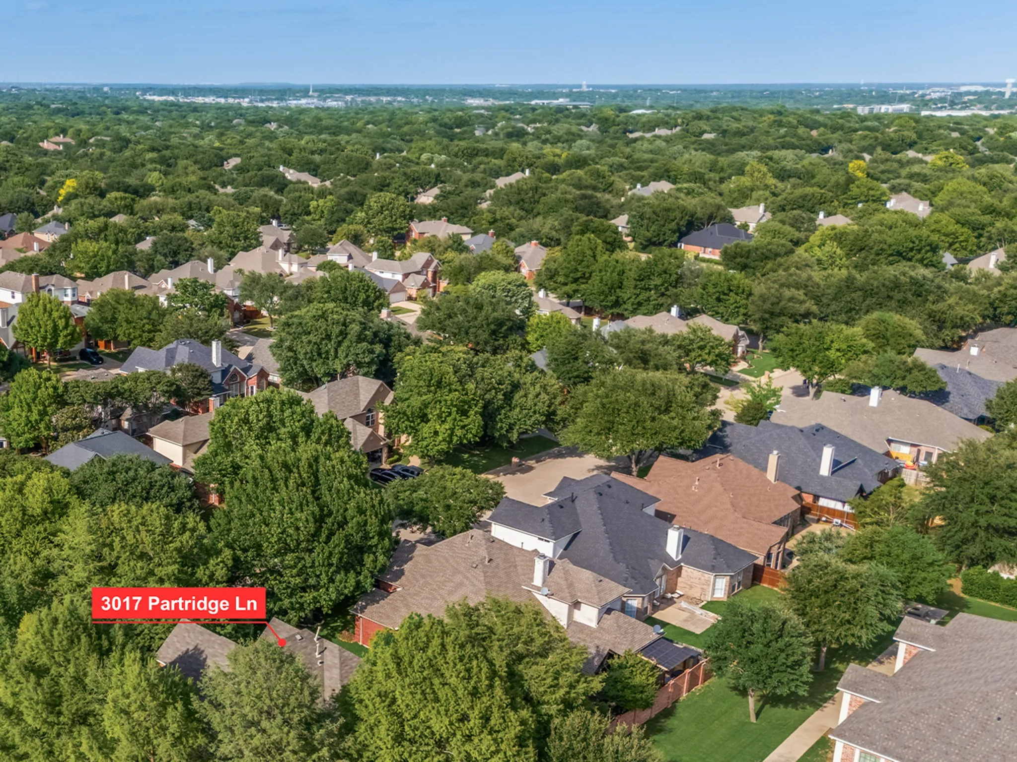 Aerial view of a residential neighborhood with a dense canopy of mature trees