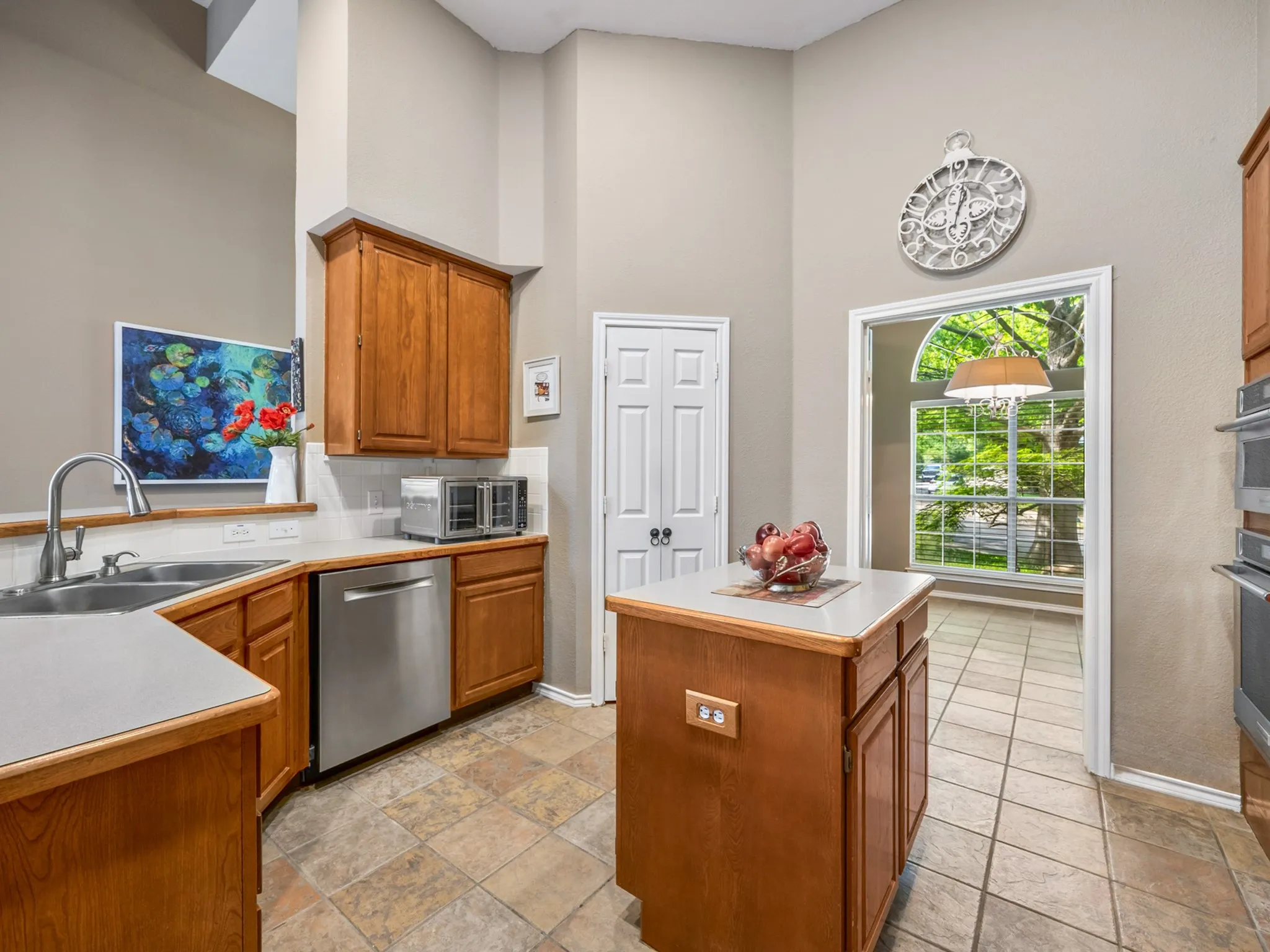 Kitchen featuring wood cabinetry, stainless steel dishwasher, and a double basin sink with a high-arc faucet