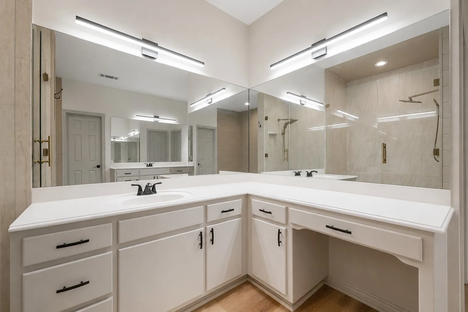 Primary Bathroom featuring a corner vanity with a white countertop, under-mount sink, and matte black fixtures