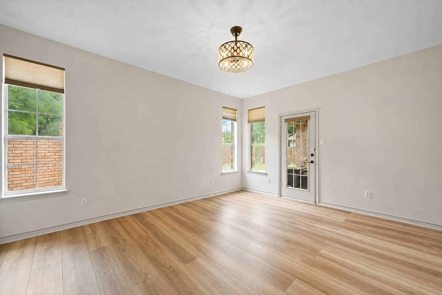 Spacious Primary Bedroom featuring wood-finish flooring, light-toned walls, and a decorative semi-flush mount light fixture