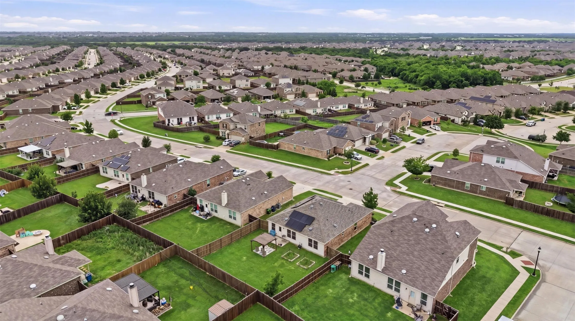 Expansive residential development featuring numerous single-story and two-story homes with shingled roofs