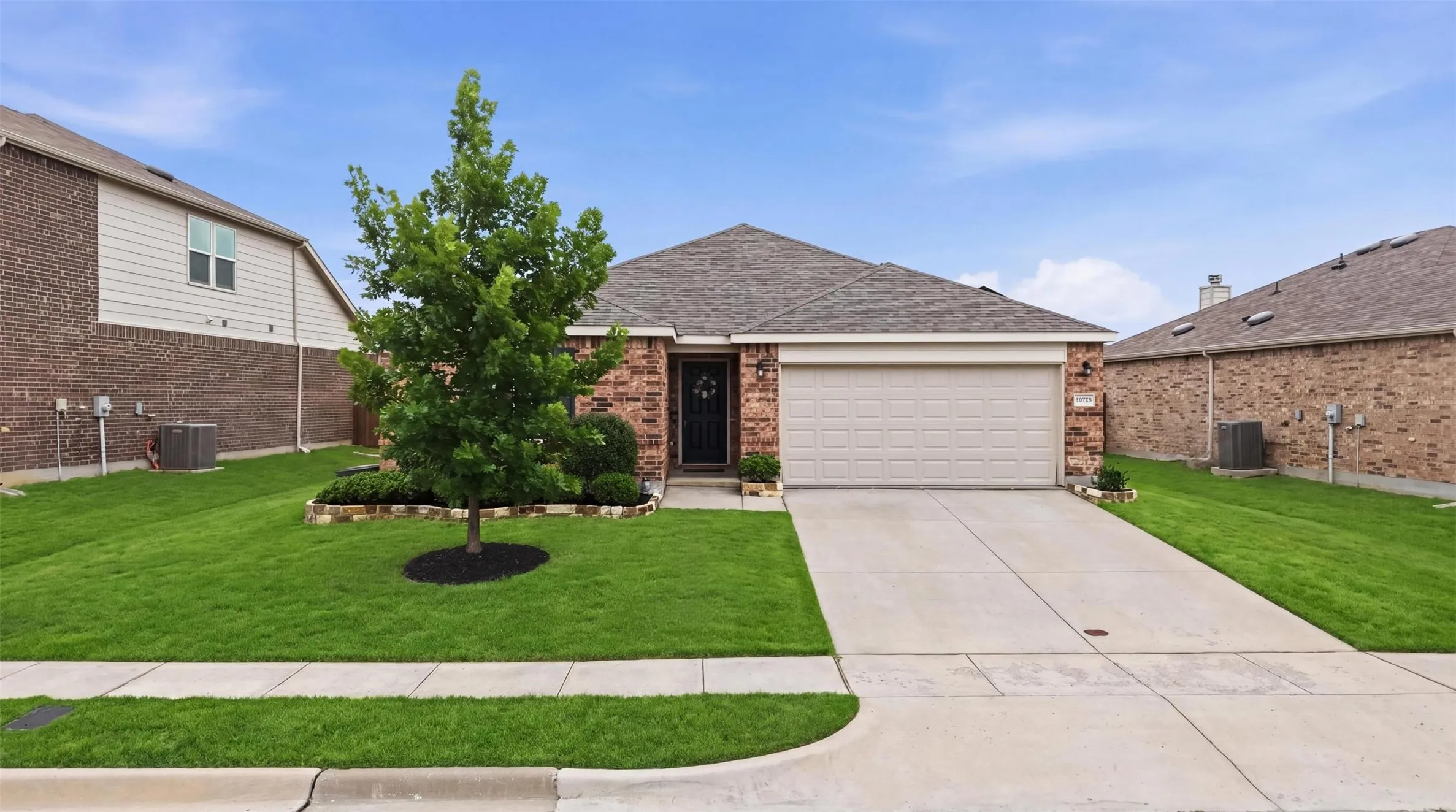 Brick and siding exterior with an attached garage and concrete driveway