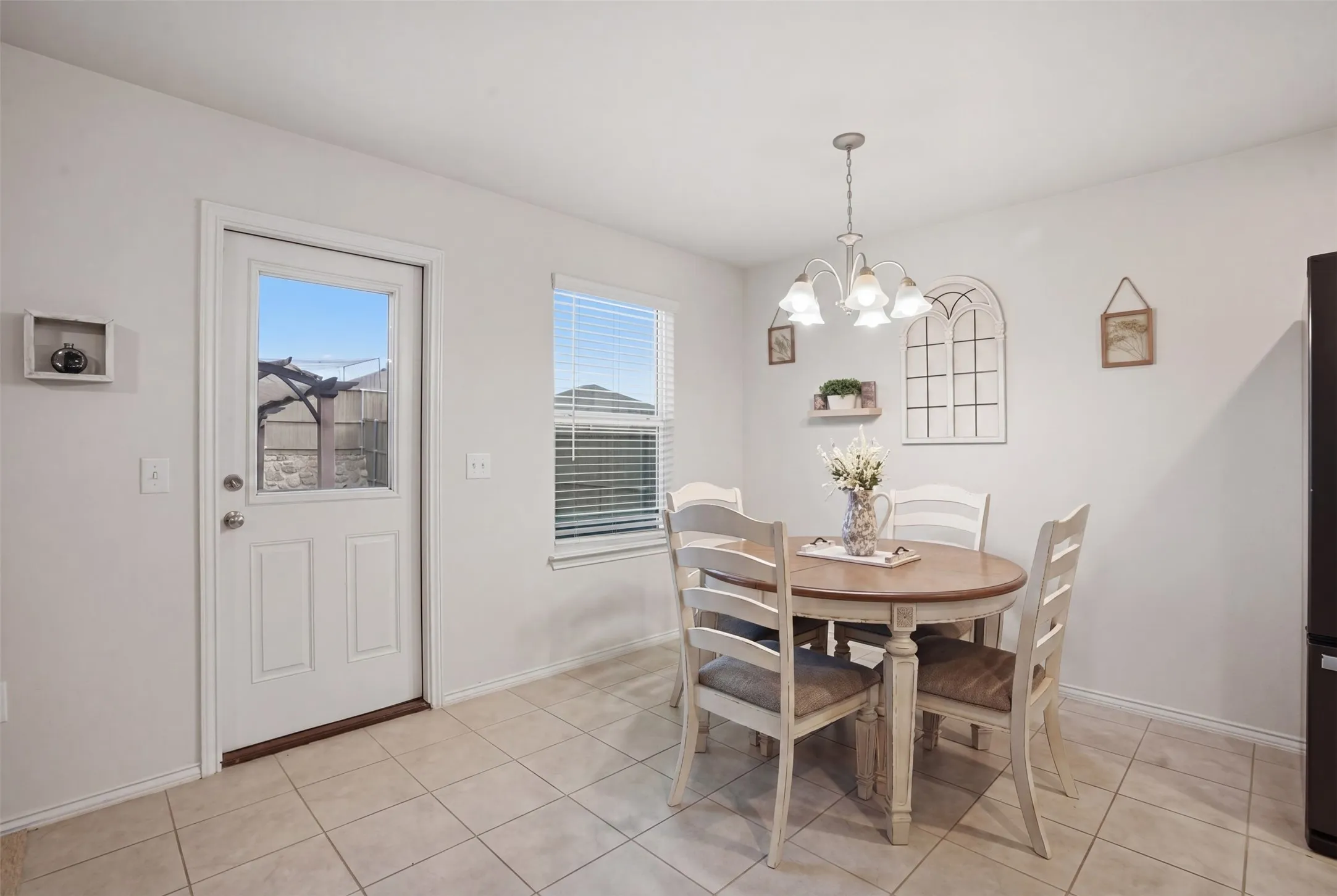 Dining area featuring tile flooring, a window with blinds, and a rear exit door with a clear pane
