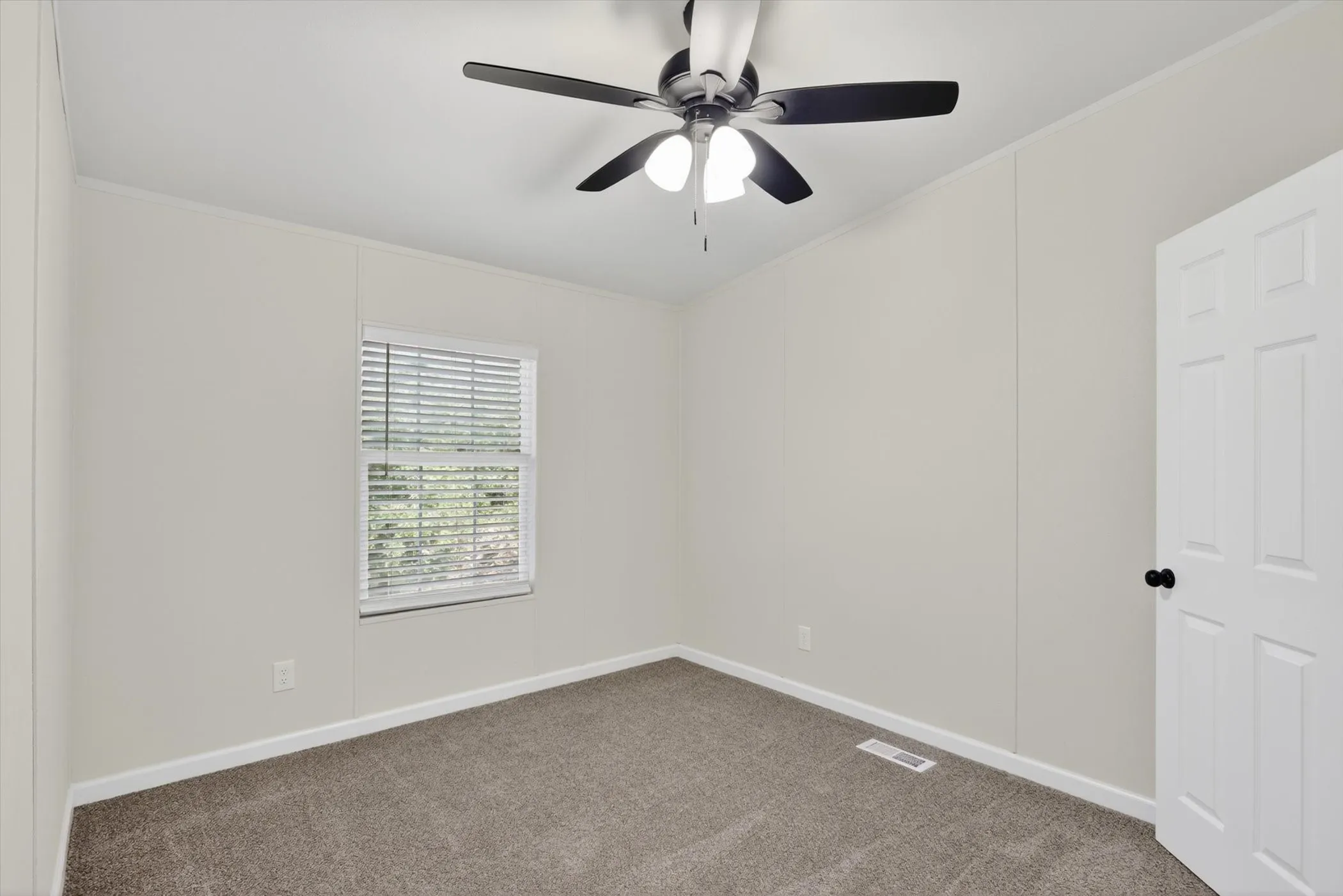 Neutral wall paneling and gray carpet flooring