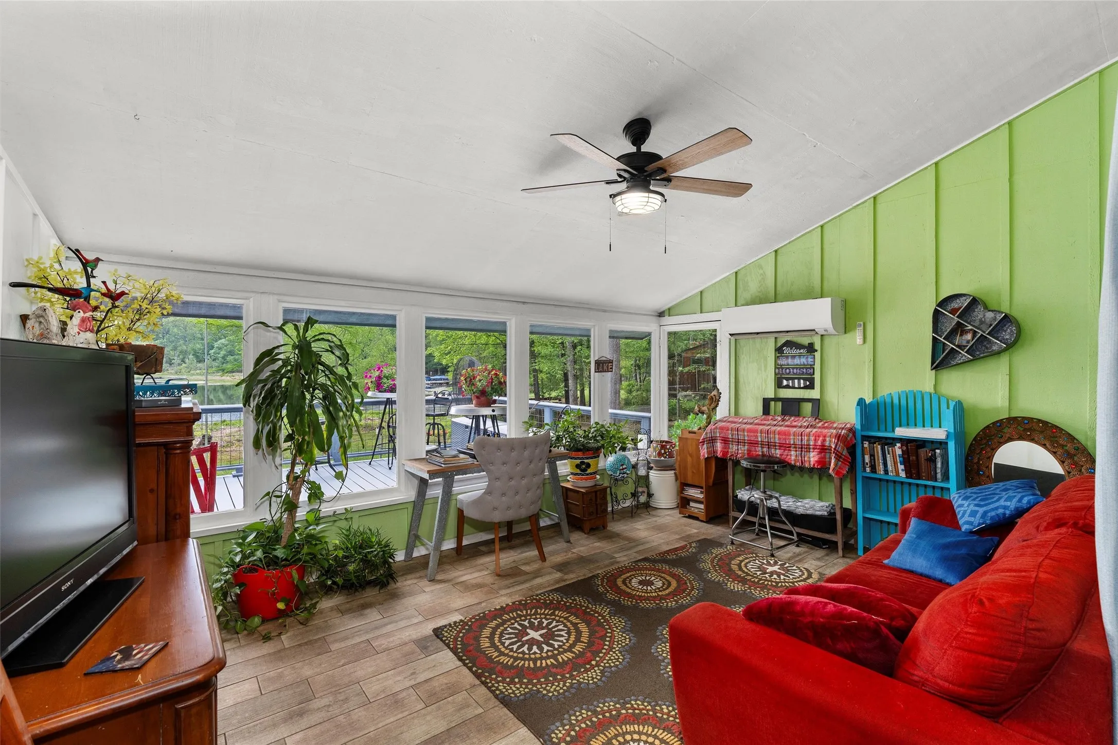 Sunroom featuring wide plank flooring, a sloped ceiling, and multiple windows providing natural light