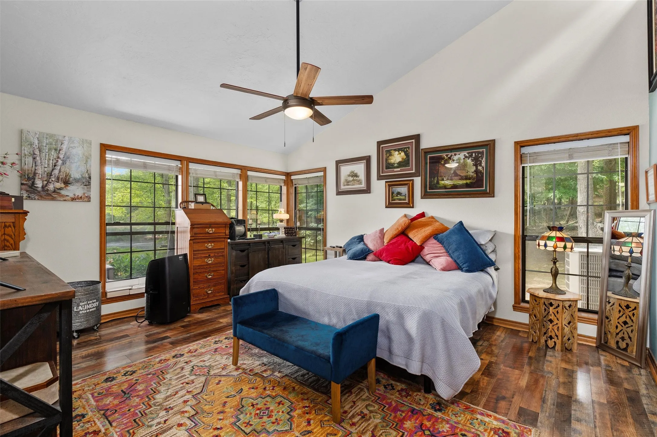 Bright interior featuring wood-finish flooring, vaulted ceilings, and a ceiling fan with light