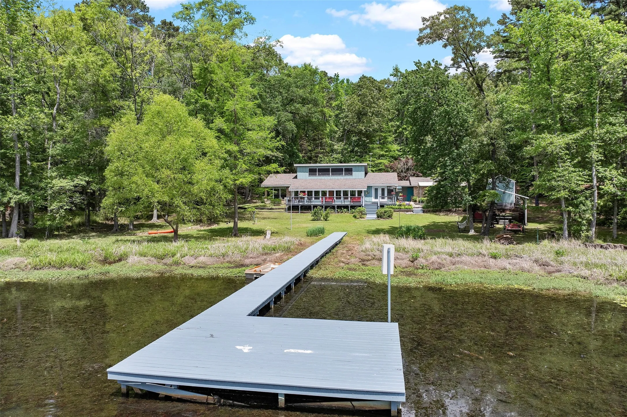 Property with extensive waterfrontage, featuring a private dock with an L-shaped end