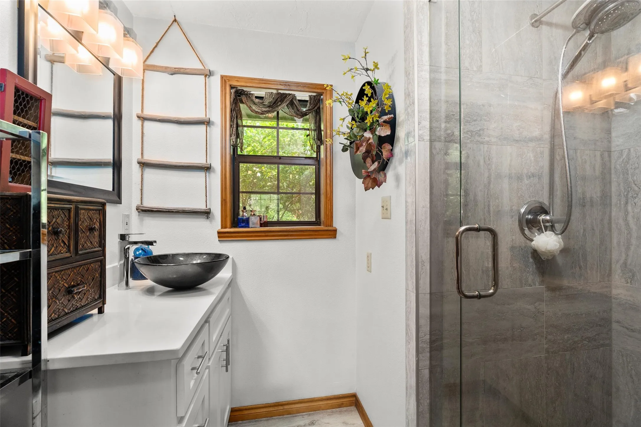 Contemporary bathroom featuring a vessel sink, white countertop, and wood-framed window