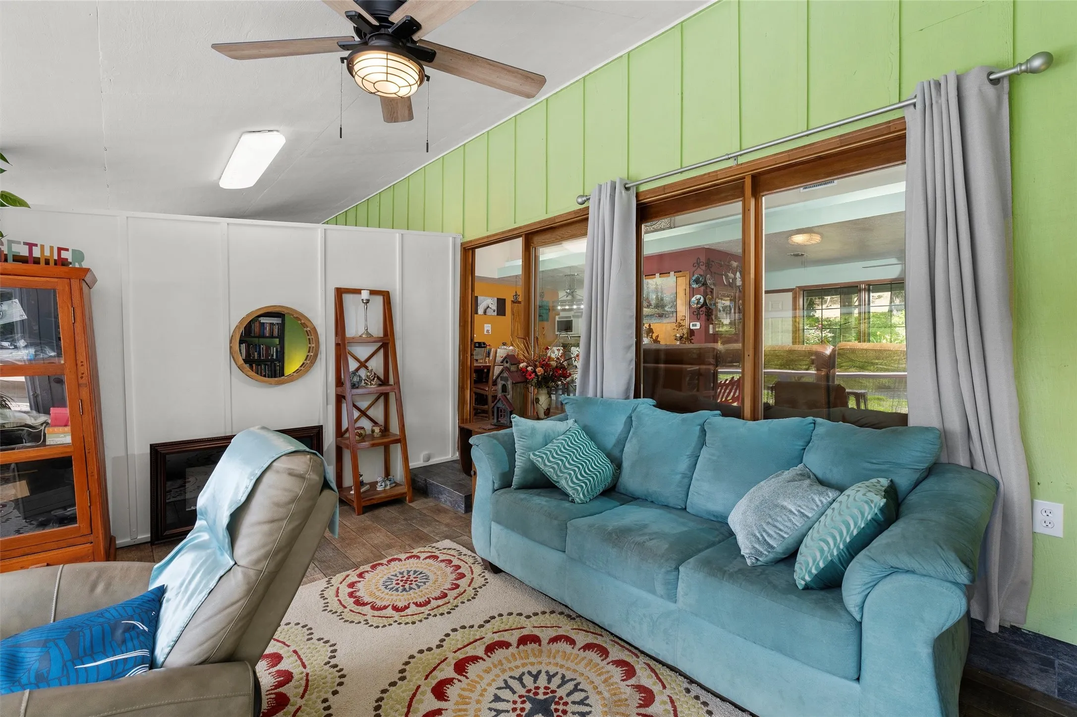 Spacious room featuring wood-finish flooring and a ceiling fan with integrated lighting