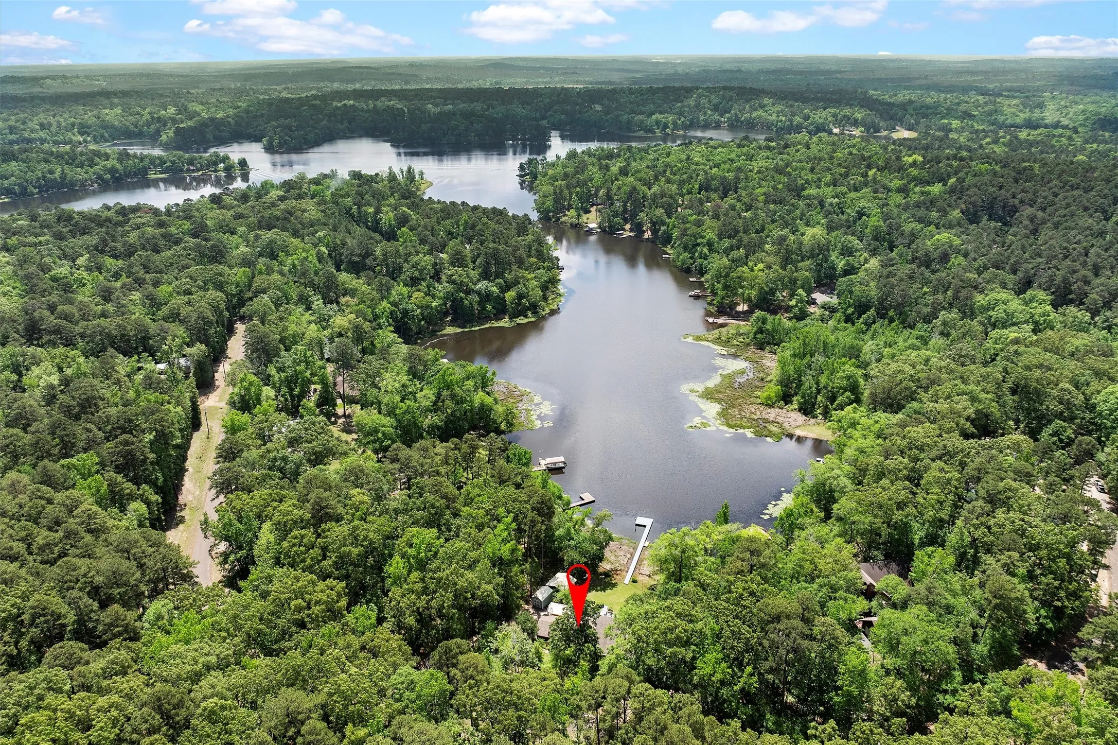 Waterfront property with private dock, surrounded by mature trees