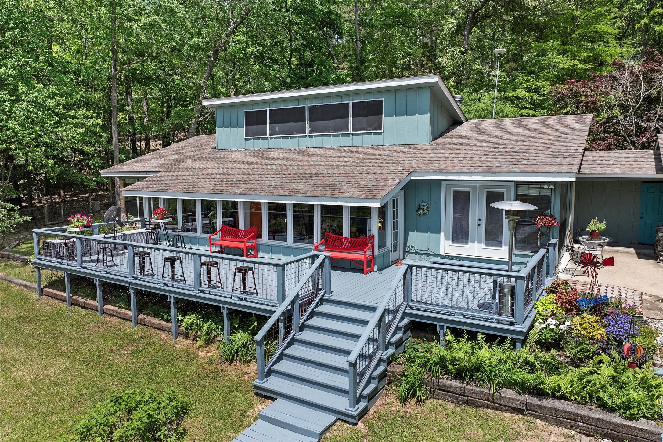 Multi-level wood deck featuring a stairway entry, wire railing system, and integrated planters