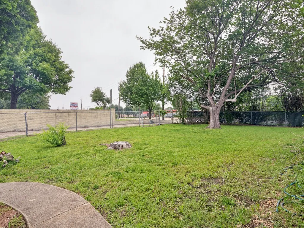 Expansive grassy yard featuring a substantial mature tree